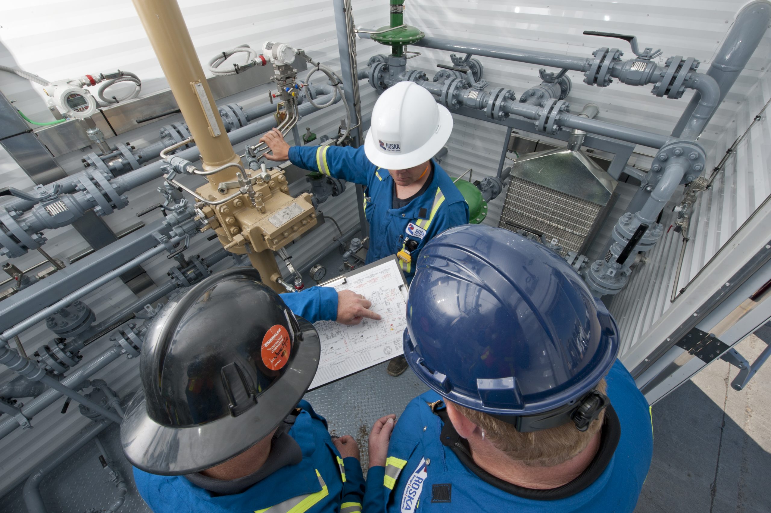 field staff looking at drawings in equipment